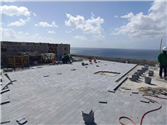 Workers paving bluestone terrace overlooking the sea at Fort George