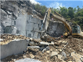 Heavy excavator extracting Crystallized stone blocks at the quarry